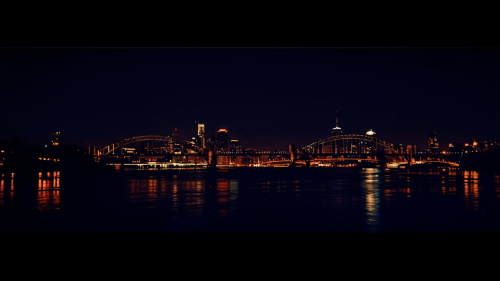 Portland Oregon skyline at night with Willamette River bridges and city lights reflecting on water
